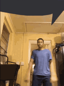 a man in a blue shirt stands in front of a door