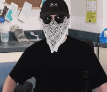 a man wearing a bandana and sunglasses is sitting in a kitchen