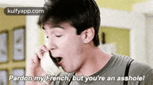 a man is talking on a cell phone and saying `` pardon my french , but you 're an asshole . ''