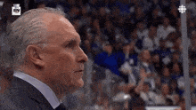 a man in a suit is watching a hockey game with a sn logo in the corner