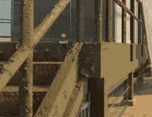 a person is standing on a set of stairs next to a building with a target on it .