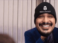 a man wearing a black beanie that says dex screener on it