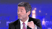 a man in a suit and tie is speaking in front of a screen that says porqueha