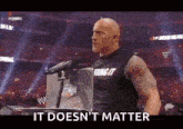 a bald man is standing in front of a microphone with the words it does n't matter on the bottom .