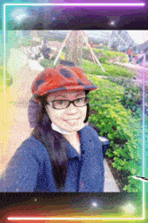 a woman wearing glasses and a red hat is smiling for the camera