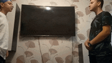 two men standing in front of a flat screen tv