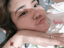 a woman with a ring on her finger is laying down with her head on her hand