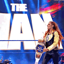 a woman is holding a wrestling belt in front of a sign that says the jan