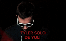 a man wearing sunglasses with the name tyler solo de yuli on the bottom