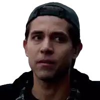 a man wearing a baseball cap and a plaid shirt looks to the side