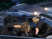 a group of people are sitting in a car with a car that says initial d on the side .