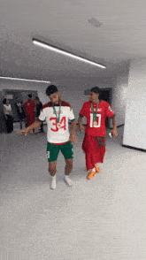 a man wearing a number 34 jersey is walking with another man wearing a number 10 jersey