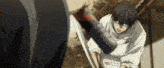 a man in a white shirt is holding a sword and fighting another man with a sword .