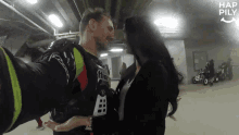 a man and a woman are kissing in a parking garage with hap pily written on the bottom right