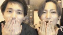 two young men are making funny faces with their hands