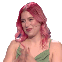 a woman with pink hair and a green dress is clapping her hands