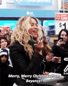 a woman singing merry merry christmas from beyonce in front of a crowd
