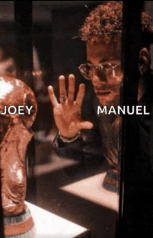 a man looking at a trophy with joey and manuel written on it