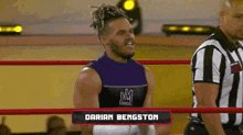 a wrestler named darian bengston is standing in a wrestling ring next to a referee .