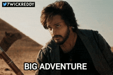 a man with a beard is holding a stick in the desert with the words big adventure above him