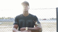 a man standing in front of a chain link fence wearing a shirt with the number 00 on it