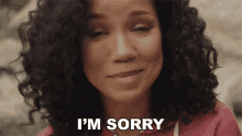 a woman with curly hair says i 'm sorry with her eyes closed