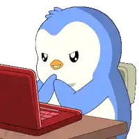 a blue penguin is sitting at a desk using a laptop