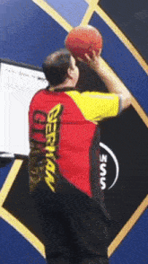 a man wearing a german shirt holds a basketball in his hand