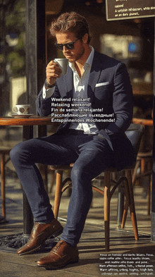 a man in a suit sits at a table with a cup of coffee
