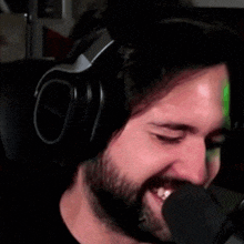 a man with a beard and headphones is making a funny face .