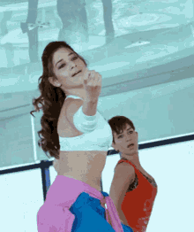 a woman in a white crop top is pointing at something