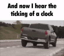 a truck is driving down a road with the words `` and now i hear the ticking of a clock '' written on it .