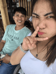 a man and a woman are posing for a picture and the man is wearing a t-shirt that says oviajim