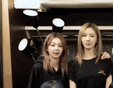 a couple of women standing next to each other with one wearing a shirt that says i love you