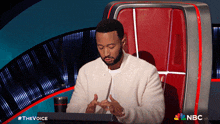 a man sitting in a chair with a nbc logo on the bottom right