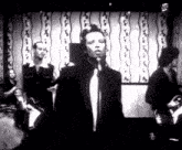 a man singing into a microphone in a band