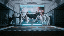 a horse is being examined in a room with a large screen behind it that says ' the grandstand ' on it
