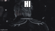 a man in a suit is standing in front of a crowd and says `` hi '' .