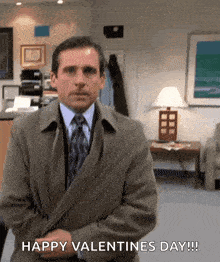 a man in a suit and tie is standing in a room and says happy valentine 's day .