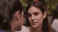 two women are looking at each other and talking to each other in a restaurant .
