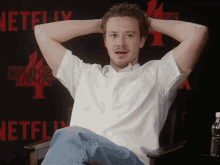a man sitting in front of a stranger things 4 poster