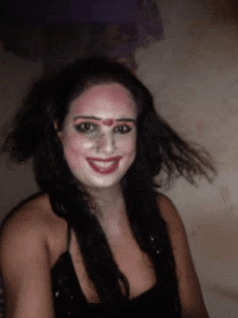 a woman with makeup on her face smiles at the camera