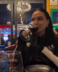 a woman is drinking from a glass that says memocrshii on it
