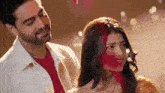 a man and a woman are standing next to each other and smiling .