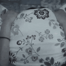 a black and white photo of a person 's back with a floral pattern