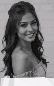 a woman is smiling in a black and white photo .