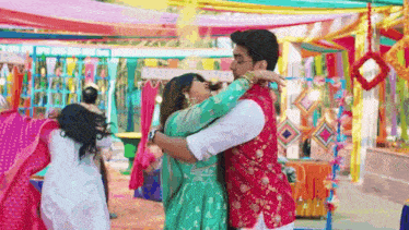 a man and a woman are hugging each other in front of a colorful background .