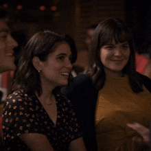 two women are sitting next to each other and smiling for the camera