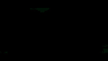 a green light is shining on a black surface in a dark room .