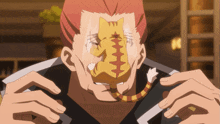 a man with a cat mask on his face eating something
